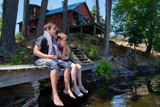2 boys beside lake